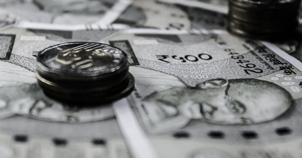 A detailed close-up of Indian currency notes and coins, highlighting financial themes.