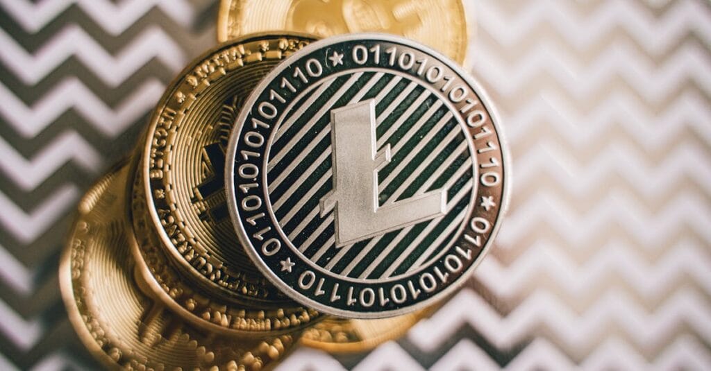 Close-up of Litecoin and Bitcoin coins on a chevron background, symbolizing cryptocurrency and modern finance.