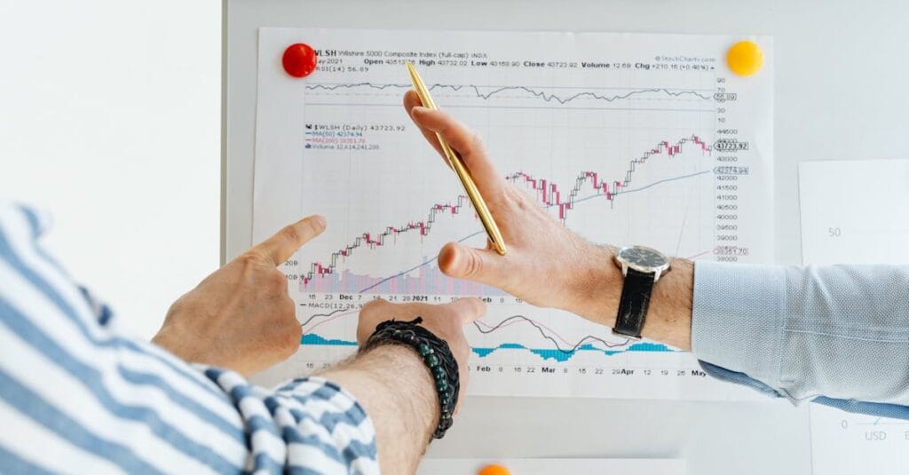 Professionals analyzing financial charts at a whiteboard meeting.
