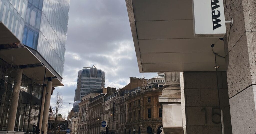A bustling street in Greater London featuring modern architecture and a WeWork sign. Daytime city scene.